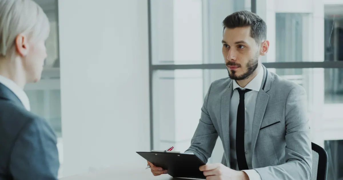 Two people discussing a document during a job interview in an office.